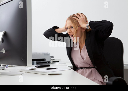 Verzweifelte junge Frau im Büro Stockfoto