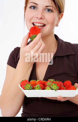 junge Frau isst Erdbeeren Stockfoto