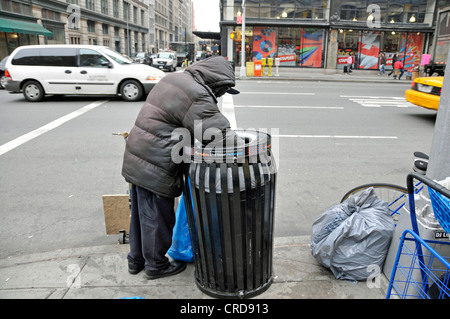 Obdachloser in einem Mülleimer für verwertbare Dinge, USA, New York City, Manhattan suchen Stockfoto