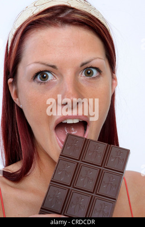 junge Frau, die einen Schokoriegel essen Stockfoto
