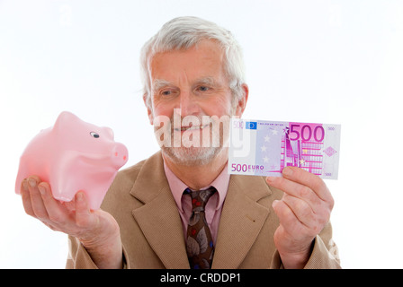 älterer Mann mit Sparschwein und Geld Stockfoto