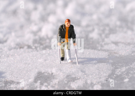 Figur mit Bein in Gips im Schnee Stockfoto
