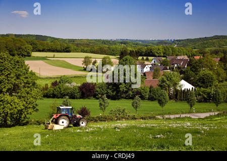 Traktor auf einer Wiese vor einem Dorf, Sprockhoevel, Ruhrgebiet, Nordrhein-Westfalen, Deutschland Stockfoto