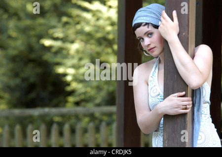 Porträt einer schönen Frau mit Headress, stützte sich auf einen Beitrag, Deutschland Stockfoto