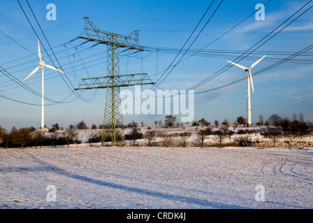 Windkraftanlagen und Strommasten Uckermark-Kraftwerks in einer winterlichen Landschaft, erzeugten Strom Regional durch Stockfoto