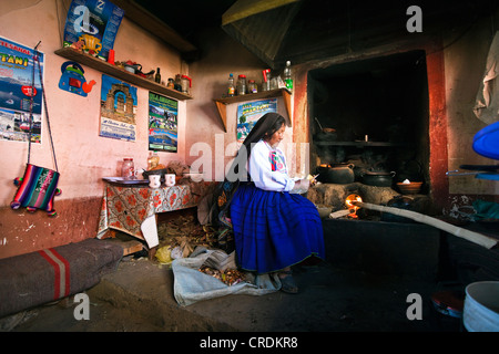 Hausfrau am Herd in ihrer Küche, die traditionelle Kleidung des Amantani-Quechua, Isla Amantani im Titicaca-See Stockfoto