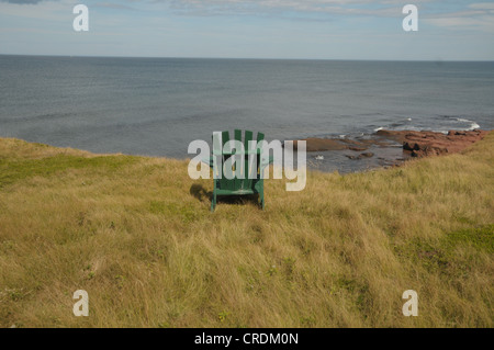 Ein Stuhl sitzt auf den roten Klippen in Hermanville, Prince Edward Island, Kanada. Stockfoto