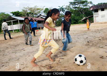 Kinder spielen Fußball auf dem Schulhof vor Beginn des Unterrichts, in einem Dorf ohne Straße Zugang die Stockfoto