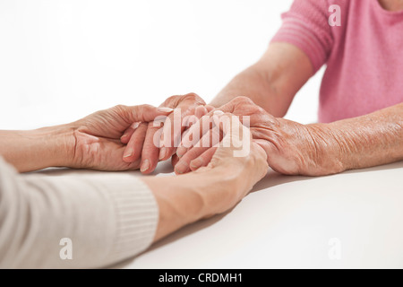 Junge und ältere Frau Hand in Hand Stockfoto
