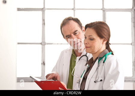 Arzt und eine Ärztin besprechen Patientenakten Stockfoto