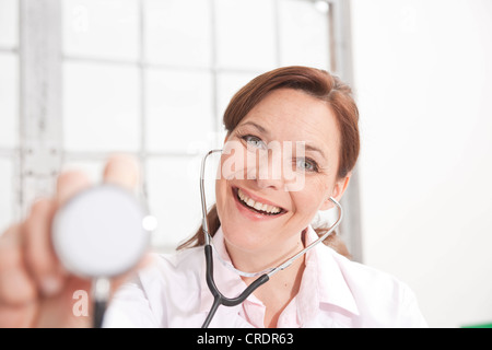 Frau mit einem Stethoskop in Richtung der Kamera Lächeln Stockfoto