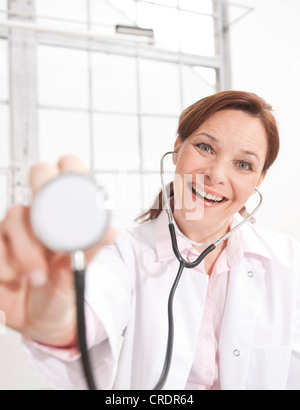 Frau mit einem Stethoskop in Richtung der Kamera Lächeln Stockfoto
