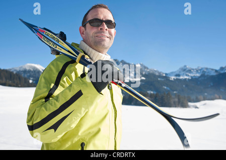 Mann mit Langlaufskiern in den Bergen Stockfoto