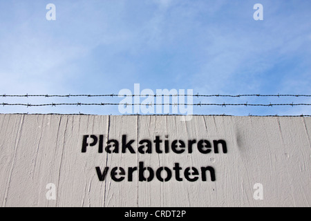 Besprüht-Schriftzug "Plakatieren verboten" oder "keine Plakate" auf einem Zaun mit Stacheldraht Stockfoto