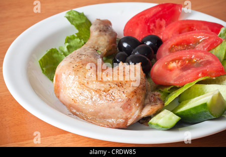 Gebratene Hühnerkeule mit Salat und frischem Gemüse Stockfoto
