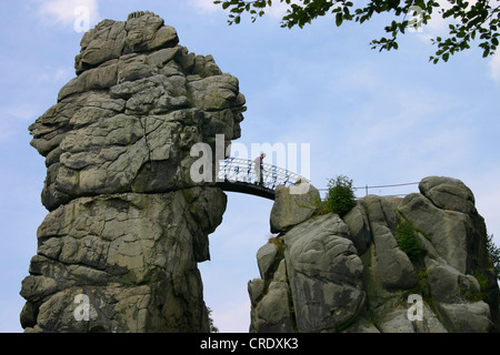 an Felsen der Externsteine kreuzt eine Person die Fußgängerbrücke zwischen zwei Felsen, Germany, North Rhine-Westphalia, Horn-Bad Meinberg Stockfoto