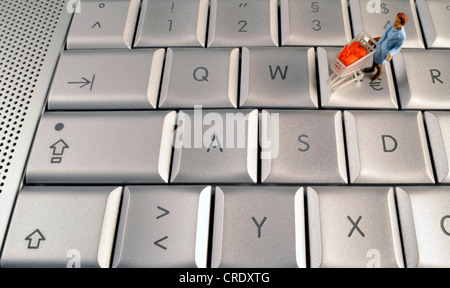 kleine Figur mit Trolley auf Tastatur Stockfoto