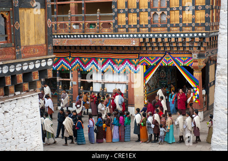 Tibetisch-buddhistische Festival Gewand Menschen tragen die traditionelle Gho stehen in einer Warteschlange, Rinpung Dzong Kloster und Festung Stockfoto