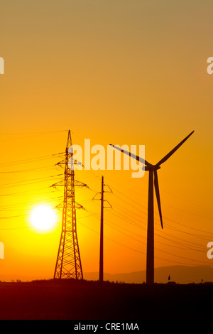 Wind Turbine und Elektrizität Masten gegen Sonnenuntergang, Marchfeld, Niederösterreich, Europa Stockfoto