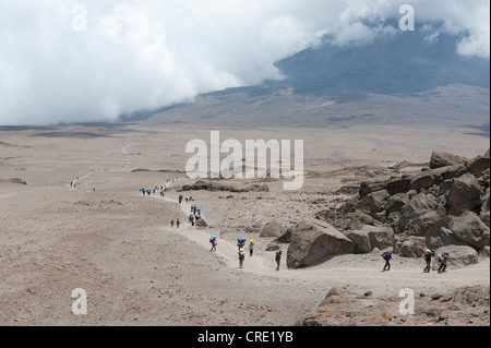 Trekking, Bergsteigen, Ansicht von der Kibo Hütte über viele Träger und Wanderer auf den Spuren des Kibo-Sattel, Kilimanjaro Stockfoto