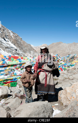 Tibetisch-buddhistische Pilger an den Dolma La Pass, 5670 m, bunten Gebetsfahnen, Vater und Sohn Pilgern entlang der Stockfoto