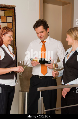 drei junge Geschäftsleute Sekt trinken Stockfoto