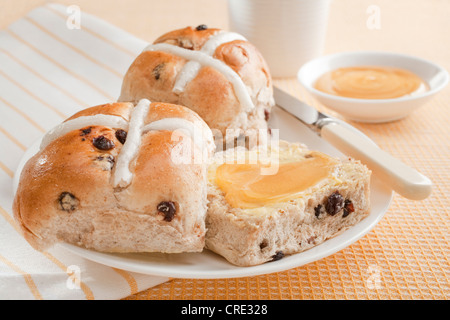 Ein extra süß behandeln für Ostern, Hot Cross Buns mit Honig bestrichen. Stockfoto