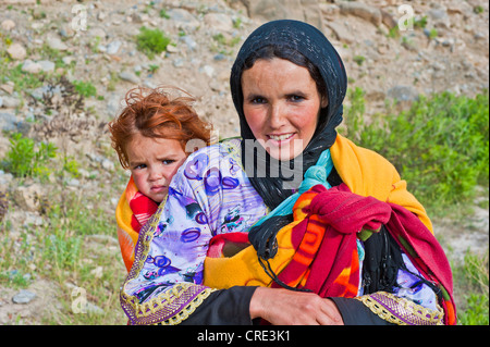 Junge Frau, die ein Kleinkind in einem Baby sling, hoher Atlas, Marokko, Afrika Stockfoto