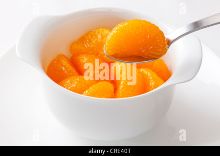 Mandarinen aus der Dose, ein Segment mit einem Löffel aufgehoben wird. Stockfoto
