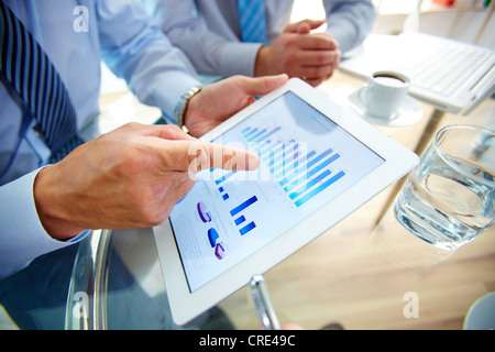 Moderne Menschen tun, Geschäft, Grafiken und Diagramme, die auf dem Bildschirm ein Touchpad demonstriert Stockfoto