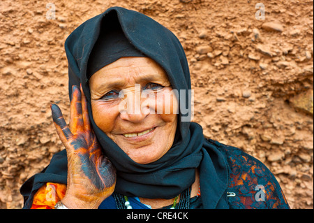 Porträt einer freundlicherweise alte Frau trägt ein schwarzes Kopftuch, ist die Palme ihrer Hand mit Henna gefärbt traditionell schwarzen Höhle Stockfoto