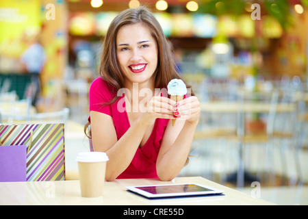 Junge Frau, die eine Pause nach dem shopping an der Eis-bar Stockfoto