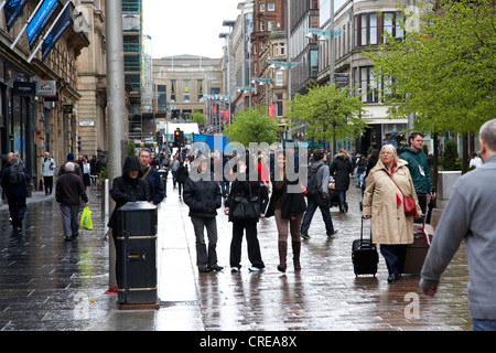 Touristen und Einkäufer bei der Buchanan Street shopping street Glasgow auf einem nassen Regentag in Schottland, Vereinigtes Königreich Stockfoto