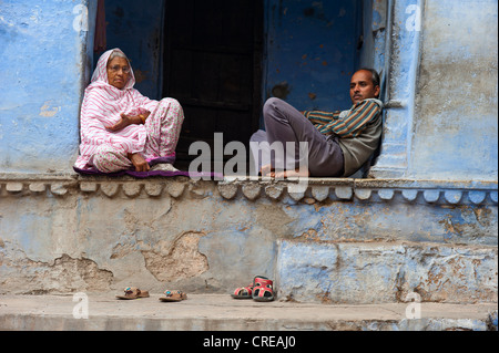 Indischer Mann und Frau sitzt barfuß in eine Tür, reden, Bundi, Rajasthan Indien, Asien Stockfoto