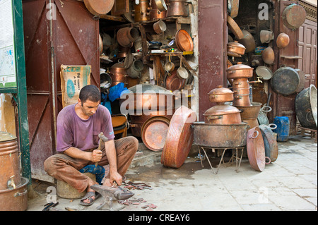 Ein Kupferschmied am Arbeitsplatz vor seinem Geschäft in der Kesselschmiede Gasse, Souk, Basar, Medina, Fes, Marokko, Afrika Stockfoto