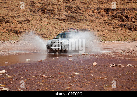 All - Terrain Vehicle, Toyota Land Cruiser, fahren durch ein Flussbett in der Nähe von Foum Zguid, Marokko, Afrika Stockfoto