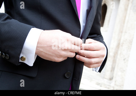 Bräutigam knöpfte seine Jacke Stockfoto