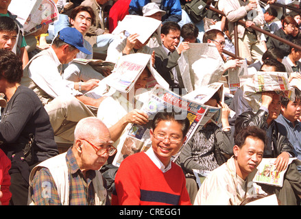 Publikum Lesen der Zeitung auf der Rennstrecke, Hong Kong Stockfoto