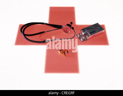 Verschiedene medizinische Utensilien auf ein rotes Kreuz als Symbol darunter liegend Stockfoto