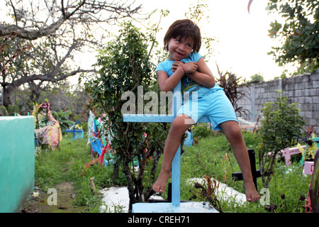Maya-Mädchen an einem Holzkreuz im Friedhof, Guatemala, Retalhuleu Stockfoto