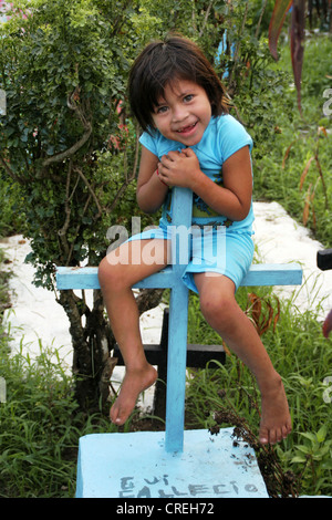 Maya-Mädchen an einem Holzkreuz im Friedhof, Guatemala, Retalhuleu Stockfoto