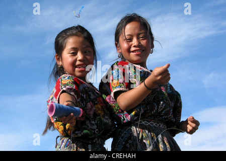 Zwei Maya-Kinder im traditionellen Kostüm lassen Sie fliegen einen Drachen in Comalapa, Guatemala, Quich, Comalapa Stockfoto