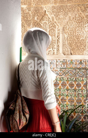 Frau mit Kopftuch, stehend auf dem Patio de Las Huasaco in des maurischen Königs Palast von Real Alcazar verschleiert Stockfoto