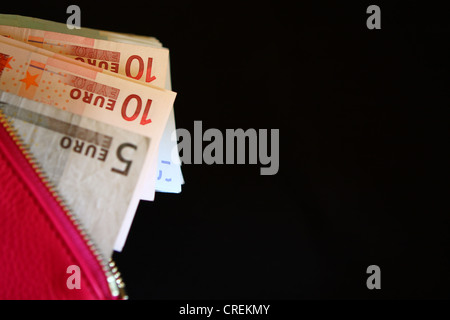 Euro-Banknoten in rosa Handtasche einer Frau Stockfoto