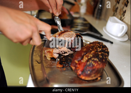 Bein der Schweinebraten gemeinsame wird am Sonntag zum Mittagessen geschnitzt Stockfoto