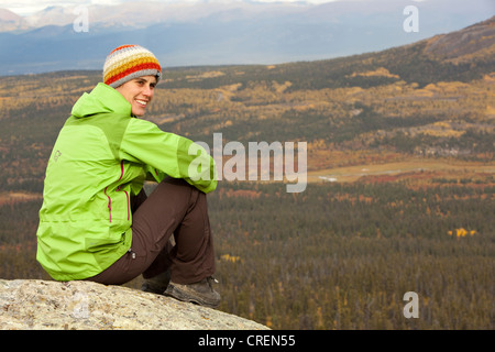 Junge Frau sitzt auf einem Felsen auf einem Berg, ausruhen, genießen, Ansicht, subalpine Tundra, Indian Summer, Lautumn, in der Nähe von Fish Lake Stockfoto