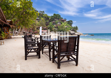 Stühle und Tisch auf dem Sandstrand mit blauem Himmel. Koh Phangan, Thailand Stockfoto