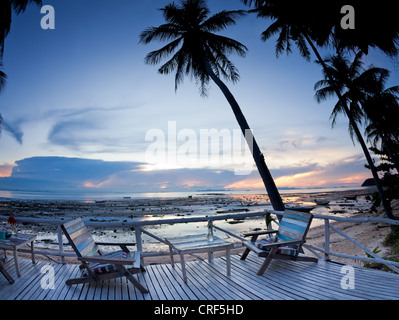 Cafe mit Terrasse im Sonnenuntergang Strand mit Palmen im freien Stockfoto