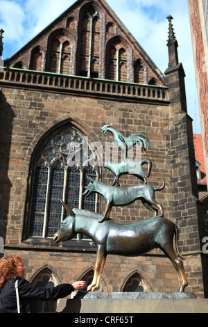 Frau, berühren den Fuß der Esel in der Skulptur der Bremer Stadtmusikanten Stockfoto