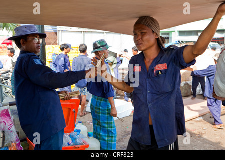 Myanmar, Burma, Yangon. Tally Mann austeilen Tally Sticks, Stauer tragen Sperrholzplatten Boot in Yangon River. Stockfoto